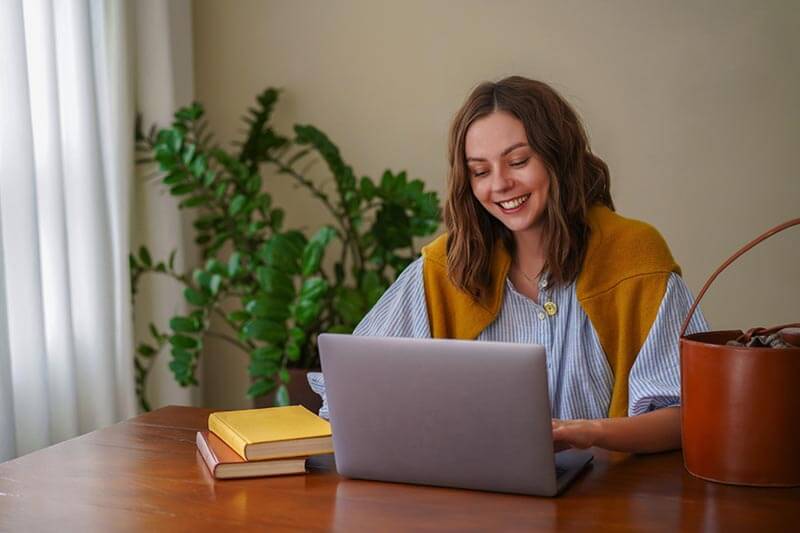 Mulher sentada trabalhando home office com notebook